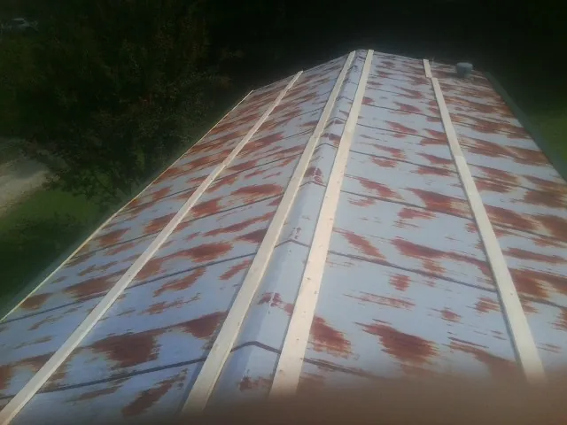 Rusted metal roof panels with new wood purlins before replacement — Storm Damage Roof Repair in Elrod by Roofing Brothers