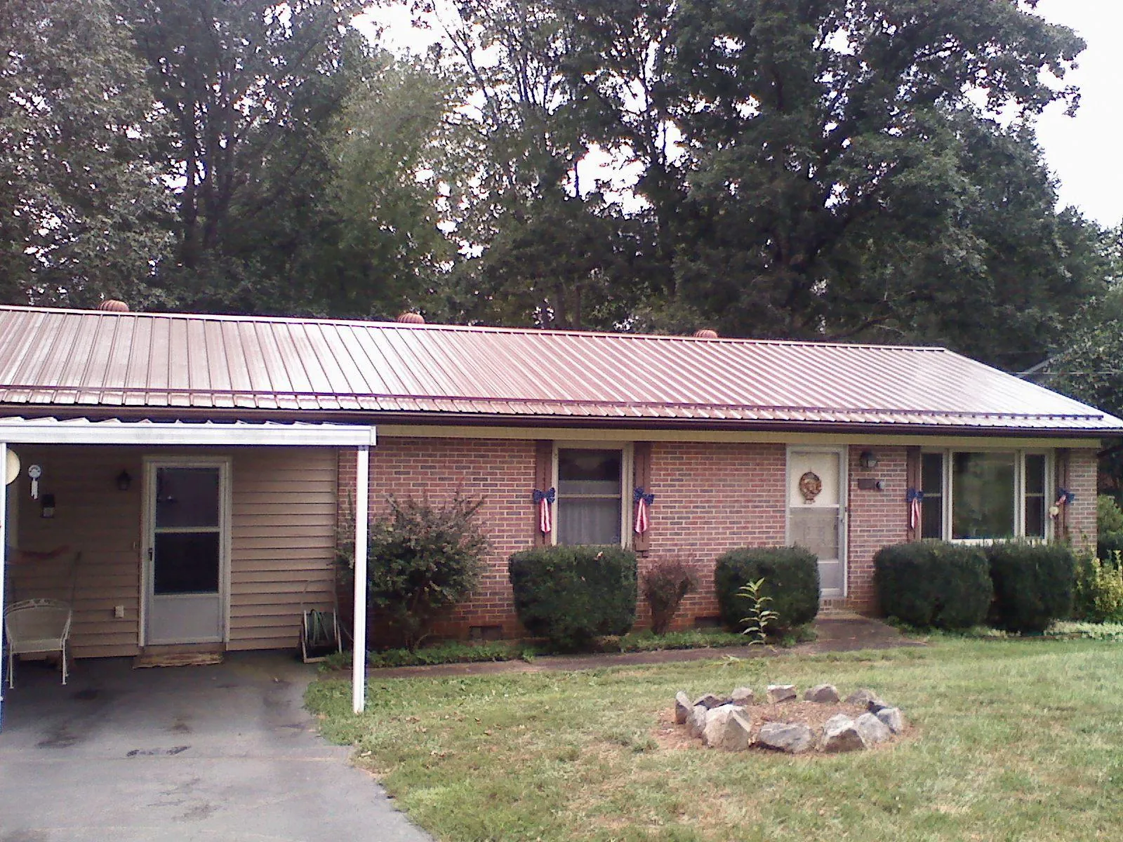 Bronze metal roof and carport on a brick ranch home — Roof Repair work by our crew in Elrod