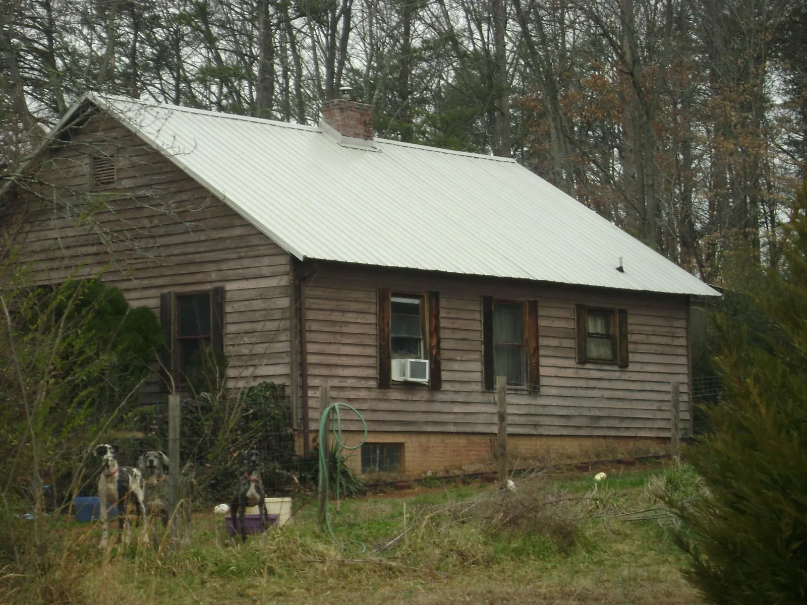 White metal roof on an old wood sided farmhouse, from a Metal Roof Installation job in Elrod